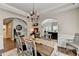 Inviting dining room features an elegant chandelier, hardwood floors, and a view into the home office at 2633 Hanriva Ct, Dacula, GA 30019
