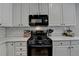 Close up on a modern gas range with subway tile backsplash and white cabinetry at 2633 Hanriva Ct, Dacula, GA 30019