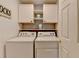 Laundry room with white cabinets, shelving, and side-by-side washer and dryer at 2633 Hanriva Ct, Dacula, GA 30019