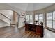 Well-lit office featuring hardwood floors, a curved wooden desk, and a view of the front yard at 2633 Hanriva Ct, Dacula, GA 30019
