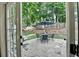 Outdoor patio with a table, chairs, and a hanging chair, surrounded by lush greenery at 2633 Hanriva Ct, Dacula, GA 30019