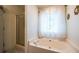 Well-maintained bathroom with a shower and separate soaking tub beneath a window with natural light at 305 Saddle Wood Dr, Canton, GA 30114
