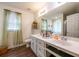 Bright bathroom featuring double sink vanity with white cabinets, green accents, and a large mirror at 305 Saddle Wood Dr, Canton, GA 30114