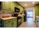 Efficient kitchen with black appliances, green cabinetry, and checkered flooring at 305 Saddle Wood Dr, Canton, GA 30114