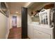Laundry room features washer and dryer, storage shelves, and doorway view to bathroom, all in one at 305 Saddle Wood Dr, Canton, GA 30114