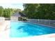 Community pool features a sunbathing area, a surrounding fence, and blue water at 305 Saddle Wood Dr, Canton, GA 30114