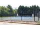 Community tennis court features a fenced perimeter with a blue playing surface at 305 Saddle Wood Dr, Canton, GA 30114