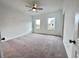 Spacious bedroom featuring neutral carpet, ample natural light from two windows, and a ceiling fan at 532 Healy Dr # 61, Cumming, GA 30040