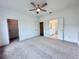 Large carpeted main bedroom featuring a ceiling fan, and entrances to a walk-in closet and bathroom at 532 Healy Dr # 61, Cumming, GA 30040