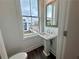 Compact powder room features a pedestal sink, window, and modern fixtures at 532 Healy Dr # 61, Cumming, GA 30040