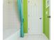 Fresh bathroom with tub, toilet, door and a bright green wall at 730 Jackson Miller Cir, Powder Springs, GA 30127