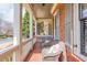 Cozy porch featuring wicker seating, brick detail, white columns, and charming traditional home architecture at 730 Jackson Miller Cir, Powder Springs, GA 30127