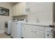 Clean laundry room featuring a sink, white cabinets, and new washer and dryer at 730 Jackson Miller Cir, Powder Springs, GA 30127