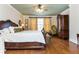 Comfortable bedroom featuring a bed, hardwood floors, armoire, and natural light at 730 Jackson Miller Cir, Powder Springs, GA 30127