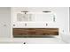 Modern bathroom with double vanity, wood cabinetry, large mirror and an adjacent tub at 2380 Greenglade Ne Rd, Atlanta, GA 30345