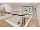 Second floor hallway with glass railing and modern chandelier at 2380 Greenglade Ne Rd, Atlanta, GA 30345