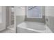 Modern bathroom features a soaking tub and separate glass-enclosed shower with gray tiled walls at 3699 Broadwick Ln, Lithonia, GA 30038