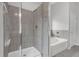 Bright bathroom showcasing a gray-tiled shower and soaking tub with modern fixtures at 3699 Broadwick Ln, Lithonia, GA 30038