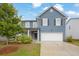 Charming two-story home with blue siding, manicured lawn, and attached two-car garage at 3699 Broadwick Ln, Lithonia, GA 30038