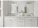 Bathroom featuring dual sinks with marble counters, white cabinets, and modern lighting fixtures at 600 Delphinium Nw Blvd, Acworth, GA 30102