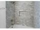 Elegant bathroom with tub/shower featuring marble tile surround, bronze fixtures and built-in niche at 600 Delphinium Nw Blvd, Acworth, GA 30102