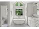 Bright bathroom featuring a soaking tub under large windows and a marble-topped vanity at 600 Delphinium Nw Blvd, Acworth, GA 30102