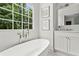 Bathroom featuring a soaking tub under large windows, marble floors, and a marble-topped vanity at 600 Delphinium Nw Blvd, Acworth, GA 30102