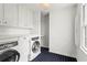 Bright laundry room with white cabinets, a washer and dryer, and patterned tile flooring at 600 Delphinium Nw Blvd, Acworth, GA 30102