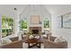 Cozy living room with stone fireplace, vaulted ceiling, and large windows showcasing the landscaped yard at 600 Delphinium Nw Blvd, Acworth, GA 30102