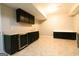 Basement featuring dark cabinets, counter, and tile floors, ideal for storage or entertainment at 8245 Mill Run Trl, Whitesburg, GA 30185