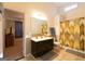 Bright bathroom with a dark vanity, shower with patterned curtain, and tile flooring at 8245 Mill Run Trl, Whitesburg, GA 30185
