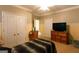 Bright bedroom with a ceiling fan, tan walls, and a TV on top of a dresser at 8245 Mill Run Trl, Whitesburg, GA 30185