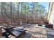 This backyard deck features multiple seating areas with views of the surrounding woods at 8245 Mill Run Trl, Whitesburg, GA 30185