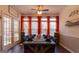 Traditional dining room with a large wooden table, red curtains, and hardwood floors at 8245 Mill Run Trl, Whitesburg, GA 30185