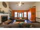 Spacious living room boasts a stone fireplace, built-in shelves, and ample natural light at 8245 Mill Run Trl, Whitesburg, GA 30185