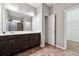 Bathroom featuring double sink vanity, large mirror, tiled floors, and shower with glass doors at 2366 Proctor Creek Enclave, Acworth, GA 30101