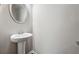 Powder room featuring a pedestal sink with a round mirror and neutral walls at 2366 Proctor Creek Enclave, Acworth, GA 30101