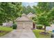 Traditional home featuring a well-manicured lawn, mature trees, and a two-car garage at 2366 Proctor Creek Enclave, Acworth, GA 30101
