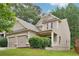 Charming home with a two-car garage, a welcoming porch, manicured landscaping, and a serene, wooded backdrop at 2366 Proctor Creek Enclave, Acworth, GA 30101
