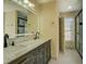 Bathroom featuring a marble countertop, double vanity, a glass shower, and exterior window at 2436 Green Hollow Ct, Conyers, GA 30012