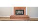 Close-up of a brick fireplace with white pillars and a modern grate insert against a light colored wall at 2436 Green Hollow Ct, Conyers, GA 30012