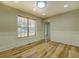 Bright living room featuring hardwood floors, wainscoting, and large window at 2436 Green Hollow Ct, Conyers, GA 30012