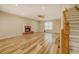 Open-concept living room featuring a fireplace, hardwood floors, and a staircase leading to the upper level at 2436 Green Hollow Ct, Conyers, GA 30012