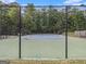 Community tennis court surrounded by a secure fence, ideal for recreational play within a scenic, wooded setting at 2436 Green Hollow Ct, Conyers, GA 30012