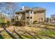 Rear exterior view of a tan two-story house featuring a deck, patio, and well-maintained yard at 3410 Kates Way, Duluth, GA 30097