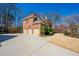Brick home with three-car garage, well-manicured landscaping, and a long driveway at 3410 Kates Way, Duluth, GA 30097