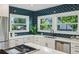 Bright kitchen with white cabinets, an island gas range, stainless appliances and blue backsplash at 1168 Mclynn Ne Ave, Atlanta, GA 30306