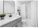 Well-lit bathroom with modern vanity, quartz countertop, shower-tub with white curtain and white flooring at 150 Chandler Trce, Covington, GA 30016