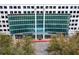 Modern building entrance featuring glass facade, stone walkway, and landscaped trees at 3324 Peachtree Ne Rd # 1813, Atlanta, GA 30305