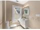 Bright bathroom featuring a window, a toilet, and a sink with bright light at 851 Courtenay Ne Dr, Atlanta, GA 30306